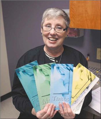 Starrla Huskins, LPN, holds pamphlets about allergies.